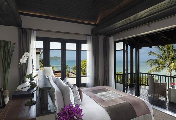 Anantara Lawana Koh Samui Resort gay-friendly hotel room. Ocean view from balcony, bed with orchids, tropical luxury.