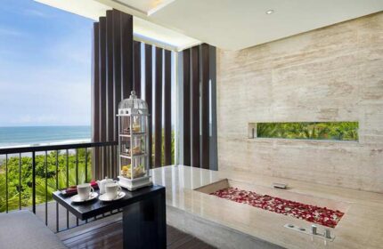 Anantara Seminyak Bali Resort gay-friendly hotel bathroom. Bathtub with rose petals, tea on balcony overlooking the ocean. Luxury travel.