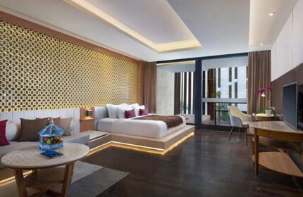Gay-friendly Anantara Seminyak Bali Resort room. Luxury hotel bedroom with king bed, seating area, and balcony. Bali travel for gay men.