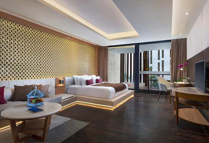 Gay-friendly Anantara Seminyak Bali Resort room. Luxury hotel bedroom with king bed, seating area, and balcony. Bali travel for gay men.