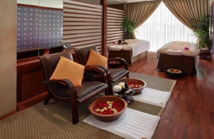 Anantara Seminyak Bali Resort spa. Gay-friendly hotel offers luxury treatments. Foot bath with flowers, massage beds, and relaxation area.