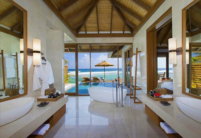 Anantara Veli Maldives Resort bathroom with ocean view. Luxury Gay-Friendly Hotel bathroom featuring tub, sinks, and beach access.