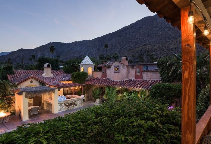 Andalusian Court, a gay-friendly hotel. Exterior view of the Spanish-style hotel with a mountain backdrop. Perfect for gay travel.