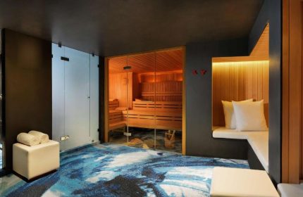 Sauna and relaxation area at the gay-friendly Andaz Amsterdam Prinsengracht Hotel. Features a sauna, shower, and seating area.