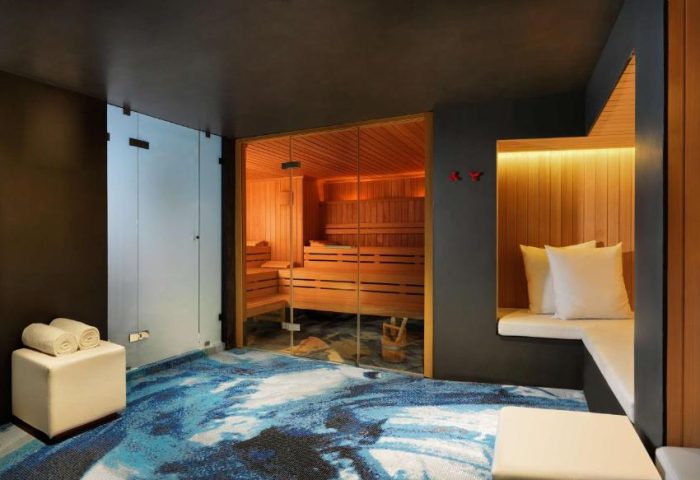 Sauna and relaxation area at the gay-friendly Andaz Amsterdam Prinsengracht Hotel. Features a sauna, shower, and seating area.