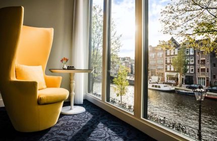 Andaz Amsterdam Prinsengracht gay-friendly hotel room. Yellow chair, canal view. Luxury gay travel in Amsterdam. Room with a view.