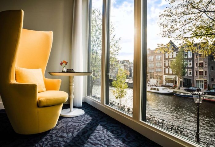 Andaz Amsterdam Prinsengracht gay-friendly hotel room. Yellow chair, canal view. Luxury gay travel in Amsterdam. Room with a view.