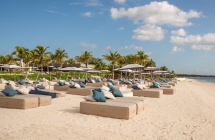 Beachfront at Andaz Mayakoba Resort Riviera Maya, a gay-friendly hotel by Hyatt. Loungers, umbrellas, and palm trees on white sand.
