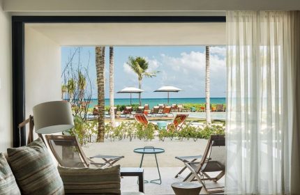 Andaz Mayakoba Resort Riviera Maya, a gay-friendly hotel by Hyatt. Ocean view from a room's patio with beach chairs and palm trees.