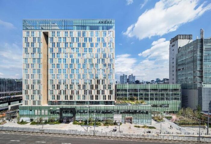 Andaz Seoul Gangnam, a gay-friendly hotel. Modern building with many windows, located in Seoul, South Korea. Urban landscape, blue sky.