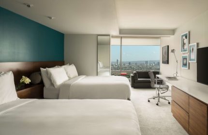 Andaz West Hollywood hotel room with two beds, desk, couch, and city view. A gay-friendly hotel offering luxury accommodations for gay travelers.