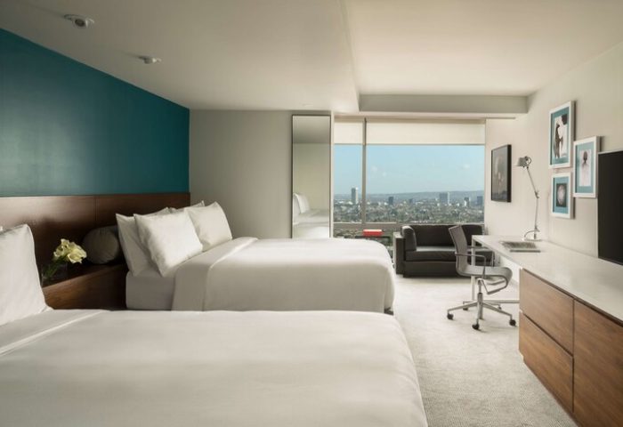 Andaz West Hollywood hotel room with two beds, desk, couch, and city view. A gay-friendly hotel offering luxury accommodations for gay travelers.