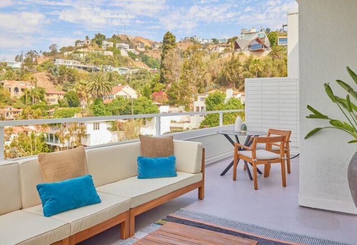 Andaz West Hollywood gay-friendly hotel balcony view. Outdoor seating, hills, and blue sky. Perfect for gay travel and relaxation.