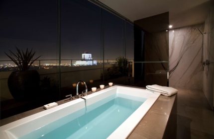 Andaz West Hollywood gay-friendly hotel bathroom. Bathtub with city views at night. Luxury gay travel accommodations. Shower.