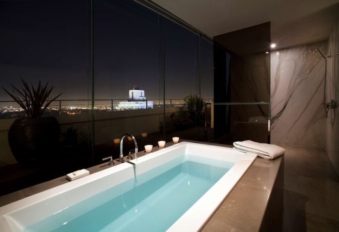 Andaz West Hollywood gay-friendly hotel bathroom. Bathtub with city views at night. Luxury gay travel accommodations. Shower.
