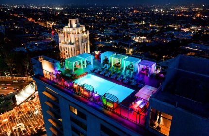 Andaz West Hollywood's rooftop pool at night. A gay-friendly hotel with colorful lights, cabanas, and city views. Perfect for gay travel.