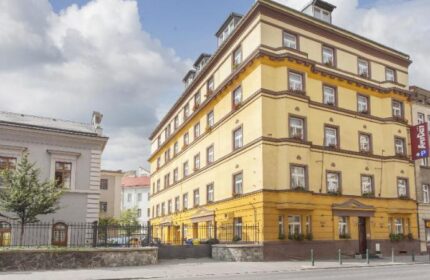 Exterior of Anyday Apartments, a gay-friendly hotel. The building is yellow with brown trim, and has several windows. Ideal for gay travel.