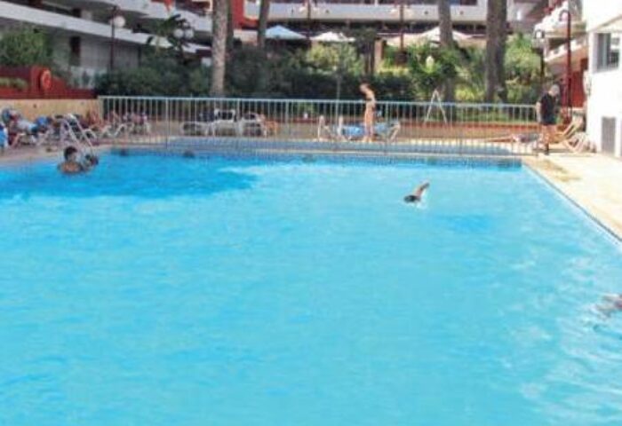 Swimming pool at Gay-Friendly Hotel Apartamentos Lido. People swim and relax in the sun. Great place to stay for gay men travelers.