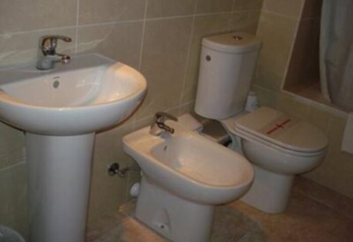 Apartamentos Lido gay-friendly hotel bathroom. Sink, bidet, and toilet in a clean, well-lit space. Ideal for gay men seeking comfortable travel.