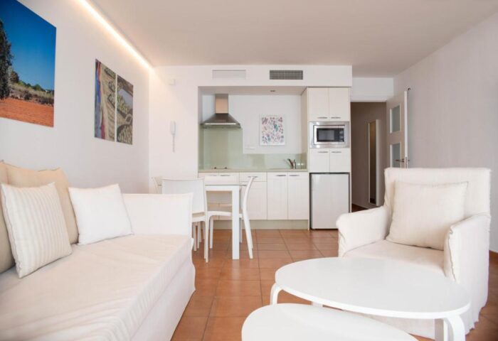 Apartamentos Llobet gay-friendly hotel: Interior view of a modern, all-white apartment with a kitchenette and seating area. Ideal gay travel.