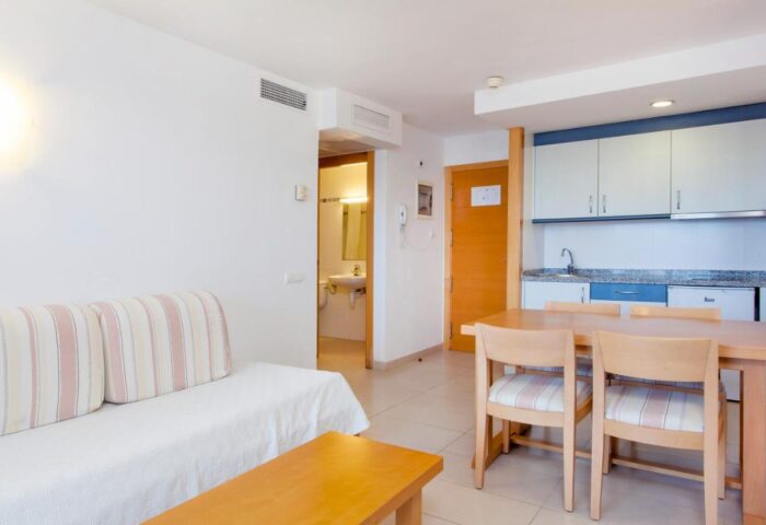 Apartamentos Mar y Playa interior. Gay-friendly hotel room with a sofa, table, and kitchenette. Great for gay travel.