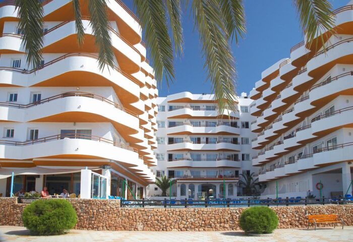 Gay-Friendly Hotel Apartamentos Mar y Playa: exterior view of the beach apartments. White buildings with orange accents and palm trees.