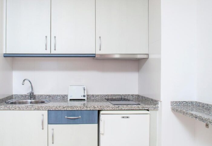 Apartamentos Mar y Playa kitchen. Gay-friendly hotel apartment features sink, cabinets, mini fridge, and counter space.