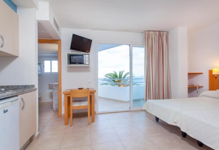 Apartamentos Mar y Playa gay-friendly hotel room. Balcony view, kitchenette, TV, bed. Ideal for gay travel, beach vacation.