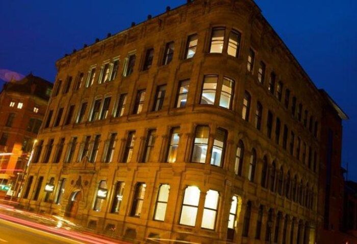 Roomzzz Aparthotel Manchester City at night. Gay-friendly hotel with modern rooms. A great choice for gay travelers visiting Manchester.