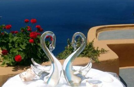 Aperto Suites, an adults-only gay-friendly hotel. Two glass swans on a table with a sea view. Romantic decor for gay couples.
