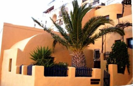 Aperto Suites, gay-friendly adults-only hotel. Exterior view with palm tree and traditional architecture. Ideal for gay travel.
