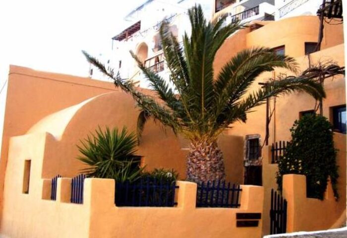 Aperto Suites, gay-friendly adults-only hotel. Exterior view with palm tree and traditional architecture. Ideal for gay travel.