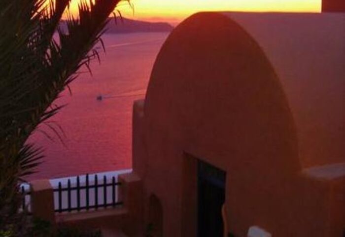 Aperto Suites adults-only gay-friendly hotel sunset view. Romantic pink sunset over the sea from this gay hotel in Santorini, Greece.