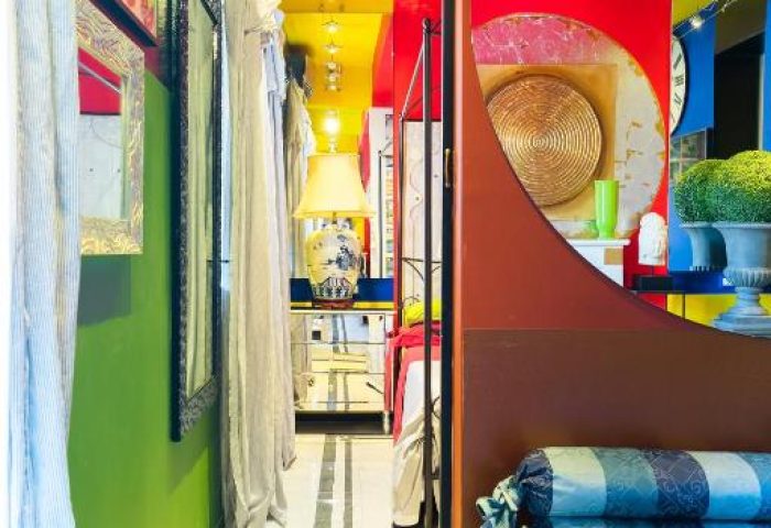 MarcoAurelio49 gay-friendly hotel room detail. Colorful design with green walls, yellow ceiling, and red accents. Unique Rome apartment interior.