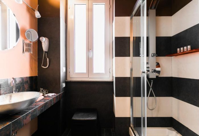 MarcoAurelio49 gay-friendly hotel bathroom. Sink, mirror, shower, and window. Stylish design for gay travelers in Rome.