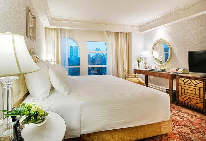 Apricot Hotel room interior. Gay-friendly hotel with a large bed, desk, and city view. Comfortable stay for gay men travelers.