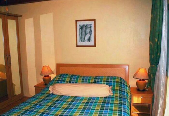Aquarius Gay Guesthouse room. Gay-friendly hotel bedroom with double bed, bedside tables, lamps, and closet. Relaxing space for gay travelers.