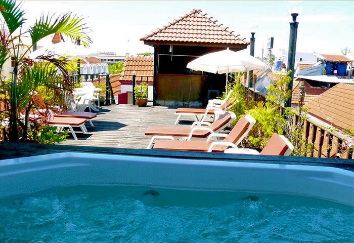 Aquarius Gay Guesthouse & Sauna rooftop. Hot tub, sun loungers, and a bar area. Gay-friendly hotel for gay men, offering a relaxing vacation.