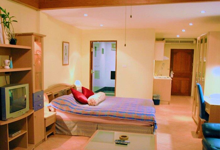 Aquarius Gay Guesthouse and Sauna room. Comfy bed with red pillows, TV, kitchenette, desk, and bathroom. Gay-friendly hotel for gay travelers.