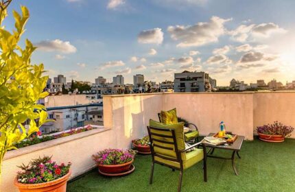 Arbel Suites Hotel's gay-friendly rooftop terrace. Chairs, table, and city views. Perfect for gay travelers seeking relaxation in a stylish hotel.
