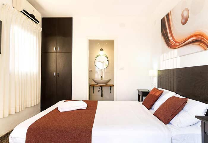Arbel Suites Hotel room. Gay-friendly hotel with bed, pillows, and bathroom. Modern design, clean, and comfortable. Ideal for gay travelers.