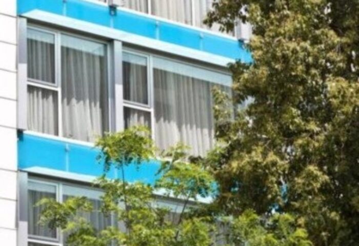 Arion Athens Hotel exterior. Gay-friendly hotel with blue accents and trees. Perfect for gay travelers seeking a welcoming stay in Athens.