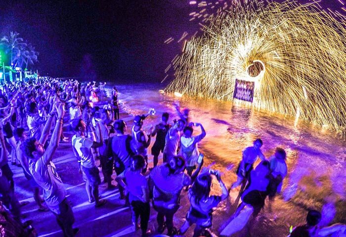 Gay-friendly Ark Bar Beach Resort party with fire show. Crowd of people enjoying the night at this gay travel destination.