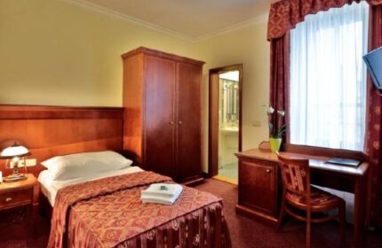 Arkada Hotel Praha room. Gay-friendly hotel featuring a single bed, wardrobe, desk, & en-suite bathroom. Ideal for gay travel in Prague.