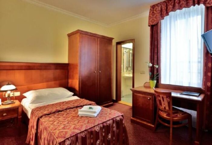 Arkada Hotel Praha room. Gay-friendly hotel featuring a single bed, wardrobe, desk, & en-suite bathroom. Ideal for gay travel in Prague.