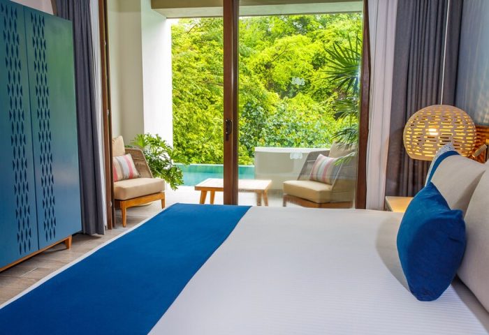 Armony Resort & Spa MGallery adults-only room. Balcony view, pool, and lush greenery. Gay-friendly hotel for all-inclusive travel. Relaxing getaway.