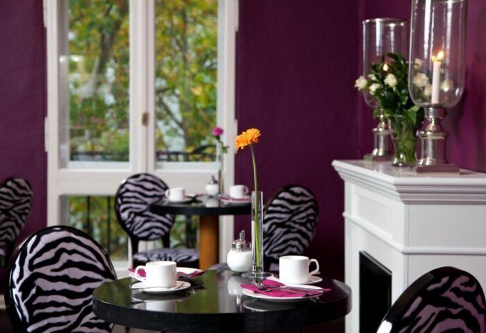 ArtHotel Connection: Gay-friendly, pet-friendly hotel room with zebra print chairs, coffee cups, and a fireplace. Stylish decor for gay travelers.