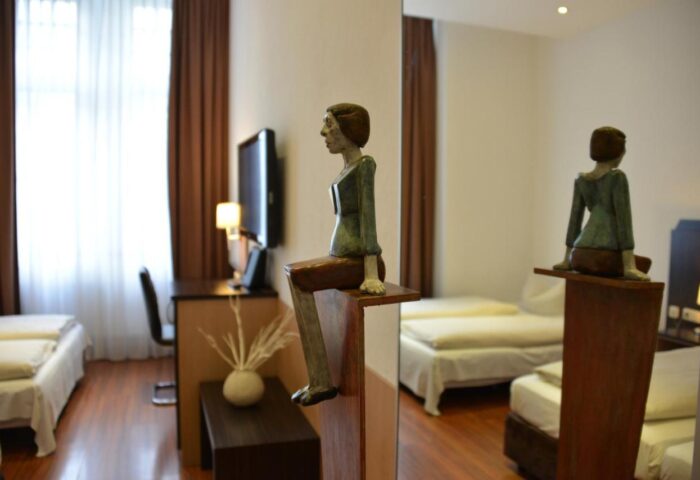 Arthotel Munich gay-friendly room. Unique design with a sculpture of a sitting person. Modern decor, comfortable beds. Ideal for gay travelers.
