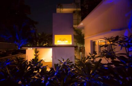 Exterior night view of Arthur&Paul, a gay-friendly, men-only hotel. Modern architecture, illuminated plants, and inviting ambiance.