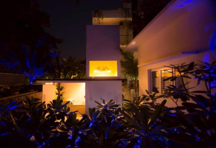 Exterior night view of Arthur&Paul, a gay-friendly, men-only hotel. Modern architecture, illuminated plants, and inviting ambiance.